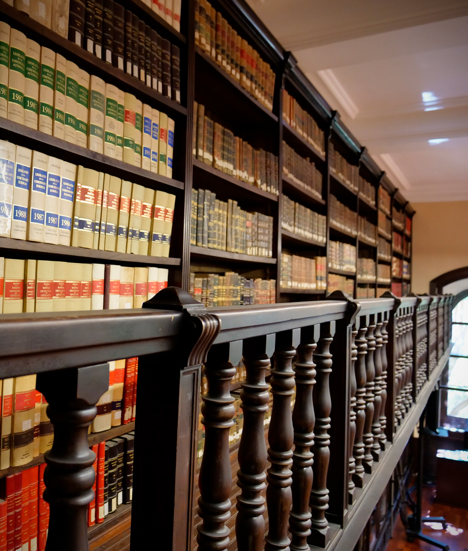 Estanterías llenas de libros en el segundo nivel de la biblioteca de la Facultad de Derecho