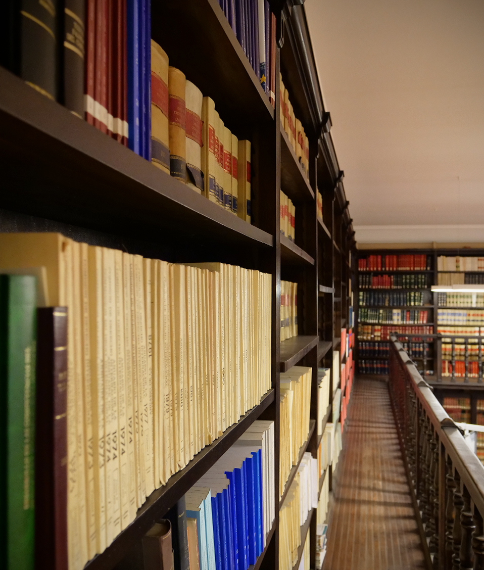 Vista de las dos plantas de la biblioteca de la Facultad de Derecho con estanterías en las paredes llenas de libros