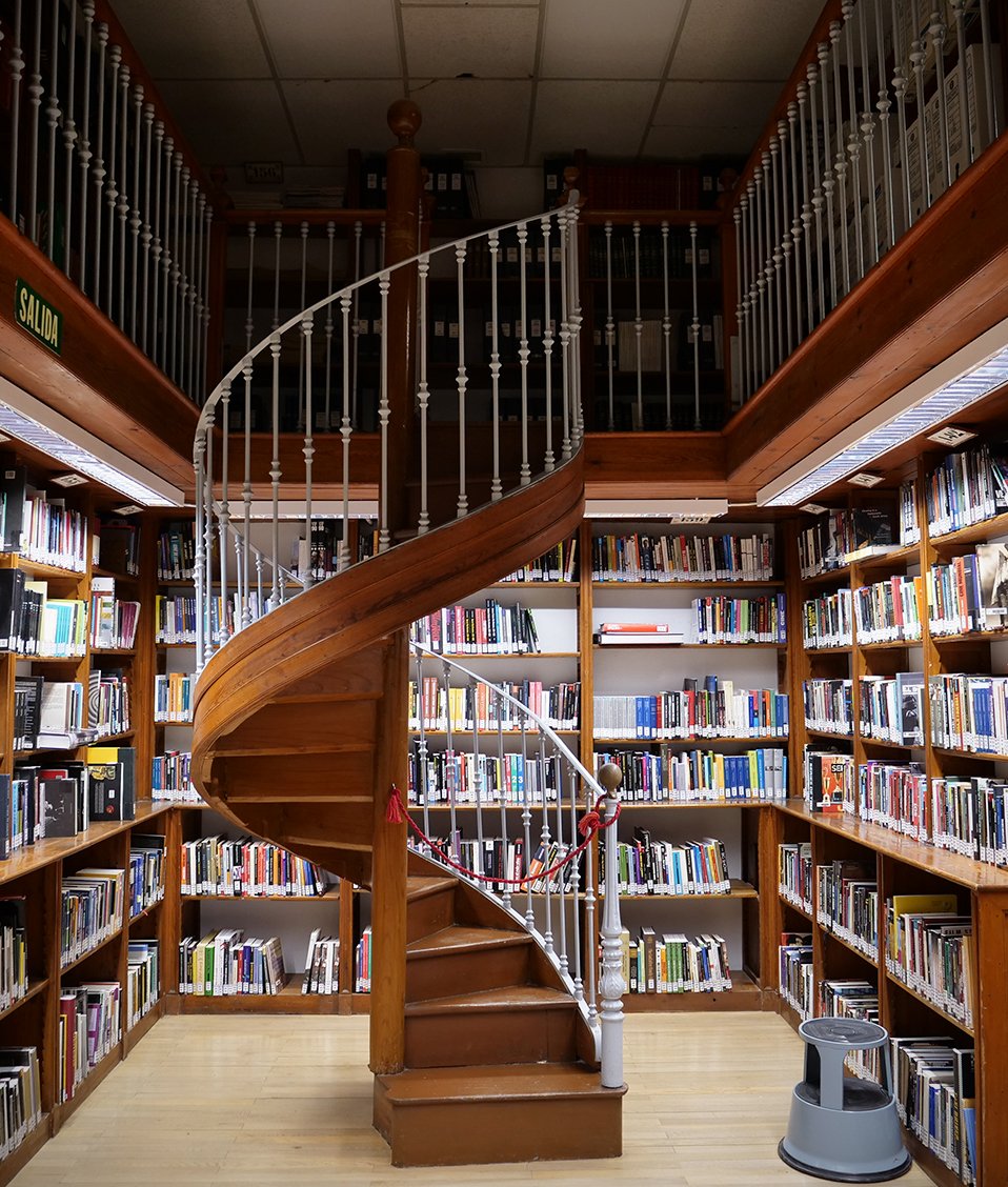 Imagen de una escalera de caracol que comunica dos plantas de la Biblioteca de la Facultad de Comunicación y Documentación