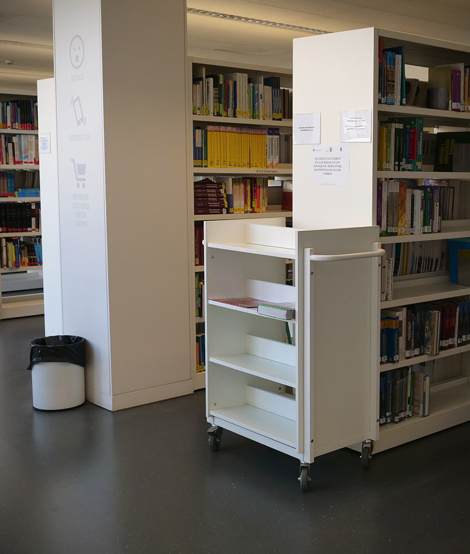 Numerosas estanterías repletas de libros dispuestas en paralelo en la biblioteca biosanitaria