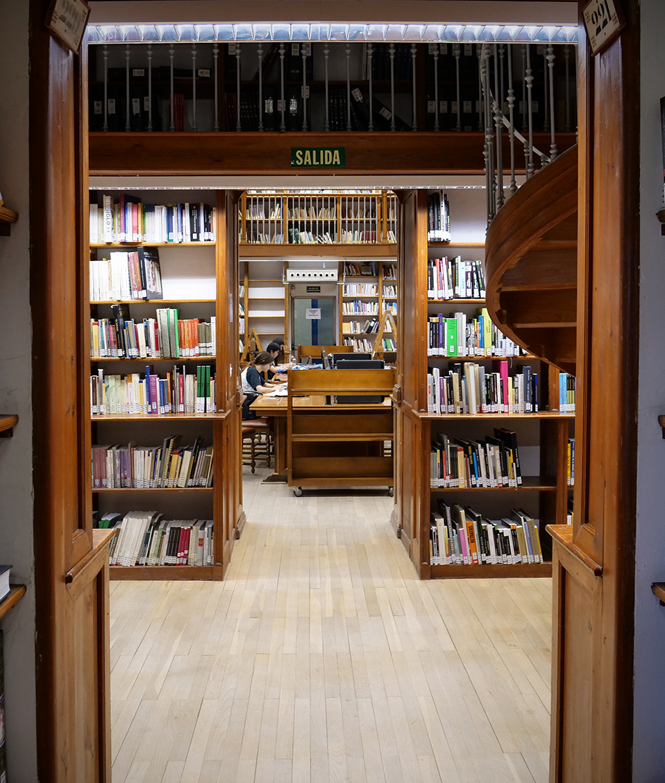 Pasillo entre dos salas de la biblioteca de la Facultad de Comunicación y Documentación con estanterías con libros a los lados